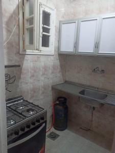 a kitchen with a stove and a sink at Villa El kheer in `Ezbet el-Dabdûba