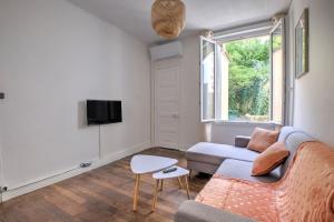 a living room with a couch and a tv at L échappée verte in Périgueux