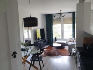 a living room with a table and a dining room at City Lux Apartament Free Parking in Leszno