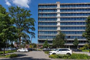 a large building with cars parked in a parking lot at U Parkhotel in Enschede