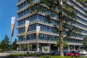 a tall building with cars parked in front of it at U Parkhotel in Enschede
