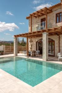 a villa with a swimming pool and a house at Pileas Villa, a Supreme Retreat by the Βeach, By ThinkVilla in Pigianos Kampos