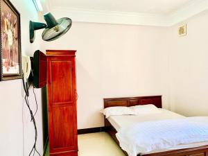 a bedroom with a bed and a lamp and a dresser at nhà nghỉ Quỳnh Vân in Lạng Sơn