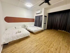 a room with two beds and a couch in it at JPO Camping Style NineInn Homestay in Kulai