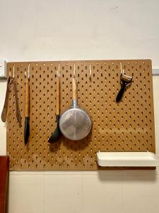 a peg board with utensils hanging on a wall at JPO Camping Style NineInn Homestay in Kulai