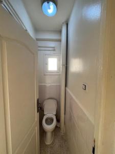 Un pequeño baño con inodoro y ventana. en Coast Haven, en Argel