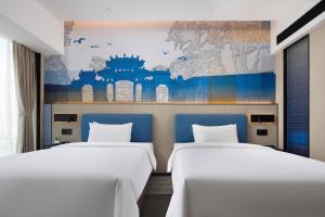 佛山市にあるHampton By Hilton Foshan Shunde Chencunの壁画のある部屋のベッド2台