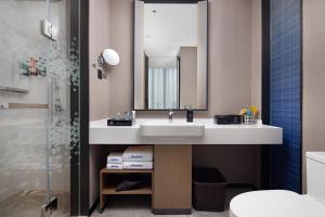 佛山市にあるHampton By Hilton Foshan Shunde Chencunの白い洗面台と鏡のあるバスルーム +49枚の写真
