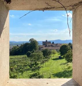 a window with a view of a field and a building at Casa Cantia at Villa Mascarello Noventa in Breganze