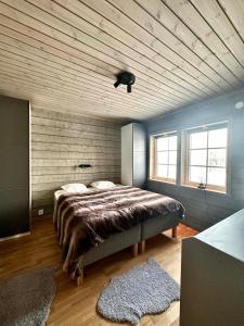a bedroom with a large bed and a wooden ceiling at Mountain Birch - Fjäll Bjorken in Åre +7 photos