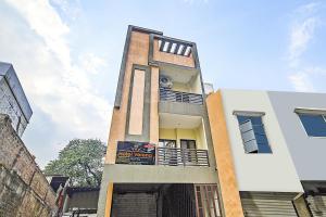 a tall white building with a sign on it at Super Collection O Verena in Indore