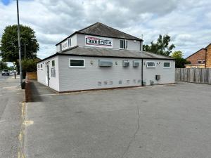 a white building with a sign on the side of it at The Studios, Dedworth Road, by Accommodation Windsor in Windsor