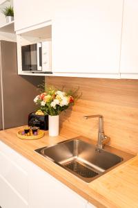 a kitchen counter with a sink and a vase of flowers at Le Cool'Nest - Proche Disney et Val d'Europe 10mn in Esbly +35 photos
