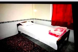 a bedroom with a white bed and a red curtain at SPOT ON D C Medi Centre in Varanasi