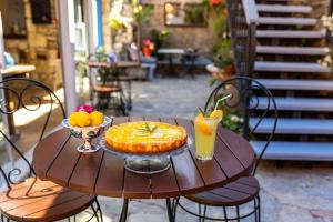 a table with a pie and a bowl of fruit on it at Alacati Eski Ev Hotel in Alacati +44 photos