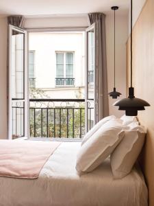 a bedroom with a bed and a large window at New Hotel Opéra in Paris