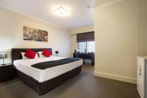 a hotel room with a bed and a desk at Enfield Hotel in Adelaide