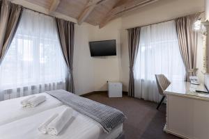 a bedroom with a bed and a desk and a television at GENESIS by Eden in Predeal