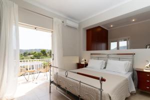 Un dormitorio con una cama y un balcón. en Kate Kontini Luxury Villa, en Tsilivi 34 fotos más