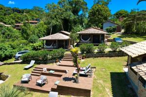 a backyard with a wooden deck and a house at CalaRosa Condomínio in Praia do Rosa