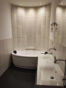 a white bathroom with a tub and a sink at Central Vienna Apartment with unique 40m2 city garden & self check in in Vienna +28 photos