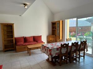 a dining room with a table and chairs and a couch at 1002 - Maison 5p à 1km de la Plage des Vallées in Pléneuf-Val-André