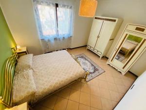 a small bedroom with a bed and a mirror at L' altro nido in San Genesio ed Uniti