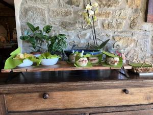 a wooden table with bowls and plants on it at Casale Sambuceto in Compiano