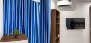 a blue curtain in a room with a tv at CH Home in Danang