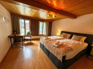 a bedroom with a large bed and a desk at City Center View Apartment 2 in Interlaken