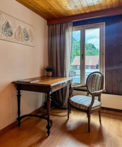 a desk and a chair in a room with a window at City Center View Apartment in Interlaken +12 photos