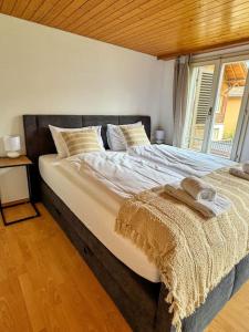 a large bed in a room with a window at City Center View Apartment 2 in Interlaken +12 photos