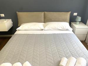 a large bed with white sheets and pillows on it at Sant'Orsola Malpighi Apartment in Bologna