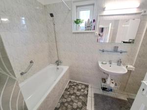a bathroom with a bath tub and a sink at Arena Apartman Siófok in Siófok +4 photos