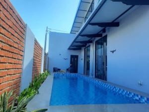 a swimming pool in front of a house at D'Pasir Lodge in Malacca