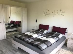 a bedroom with a large bed and a mirror at Ferienwohnung Filli mit Sauna und Pool im Haus in Prien am Chiemsee +10 photos