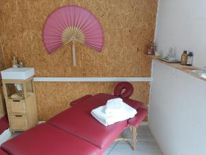 a red table with a pink umbrella on the wall at Villa Couleurs du Sud Sauvage in Saint-Joseph