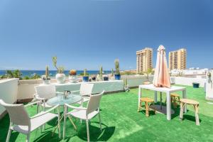 a patio with a table and chairs on a roof at Azahara Beach in Arona