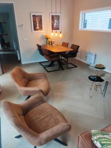 a living room with a wooden table and chairs at Sallands Chalet Hellendoorn met Hottub en Sauna in Haarle