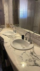 a bathroom counter with two sinks and a mirror at La casa di Sonia in Fanusa