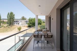a balcony with a table and chairs and a view at Endless Blue Luxury Suites in Nikiti