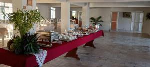 a long red table with food on it in a room at Hotel San Conrado in Salinópolis
