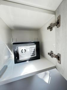 a microwave sitting on a shelf in a kitchen at tettyeapartman in Pécs +9 photos