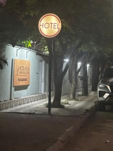 a hotel sign on the side of a street at night at Hotel Nossa Senhora de Lourdes in Trindade