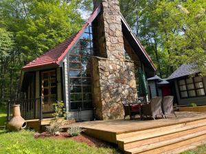 a cabin with a wooden deck with a table and chairs at Private Pool & Hot Tub at Chalet by Hidden Valley in Somerset