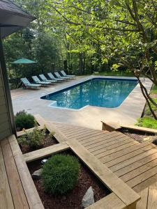 una piscina con rampa de madera y sillas y sidx sidx sidx sidx en Private Pool & Hot Tub at Chalet by Hidden Valley, en Somerset
