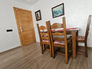 a dining room with a table and chairs and a door at Luxury Appartement With Fibre Optique, Parking & Marina Swimming Pool 10 Min By Car in Agadir