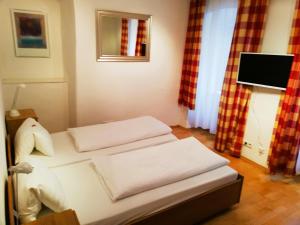 Una habitación con una cama con tres almohadas. en Living inStein, en Krems an der Donau