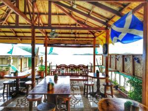 a restaurant with tables and chairs and a flag at Bellalouise Inn in Busuanga