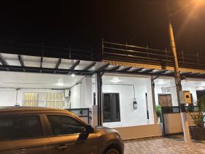 un coche aparcado delante de una casa por la noche en Lily's Homestay, en Jerantut